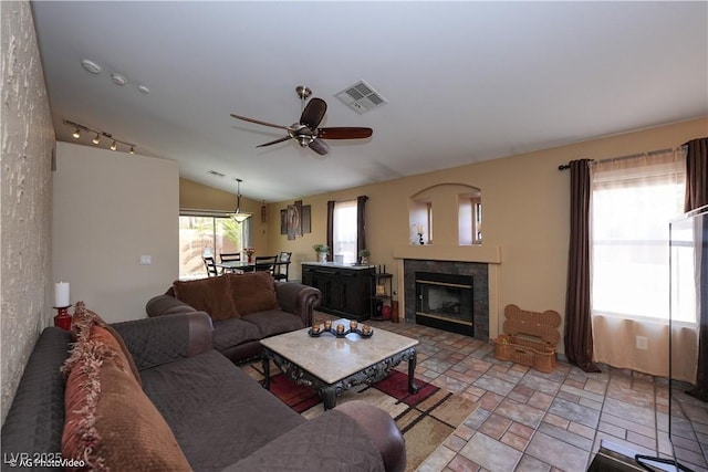 3913 Lilac Haze St, Las Vegas, NV 89147 - living area featuring vaulted ceiling, a ceiling fan, a tile fireplace, and light stone finish flooring