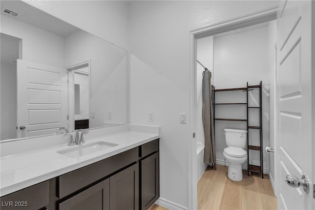 9570 Thistle Creek Ave, Las Vegas, NV 89178 - bathroom featuring vanity, wood finished floors, toilet, shower / bathtub combination with curtain, and baseboards