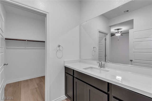 9570 Thistle Creek Ave, Las Vegas, NV 89178 - bathroom with vanity, wood finished floors, ceiling fan, a spacious closet, and baseboards