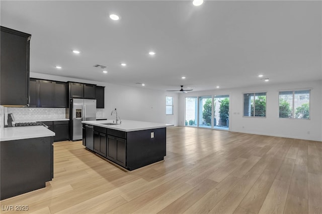 9570 Thistle Creek Ave, Las Vegas, NV 89178 - kitchen with appliances with stainless steel finishes, dark cabinetry, a sink, open floor plan, and light countertops