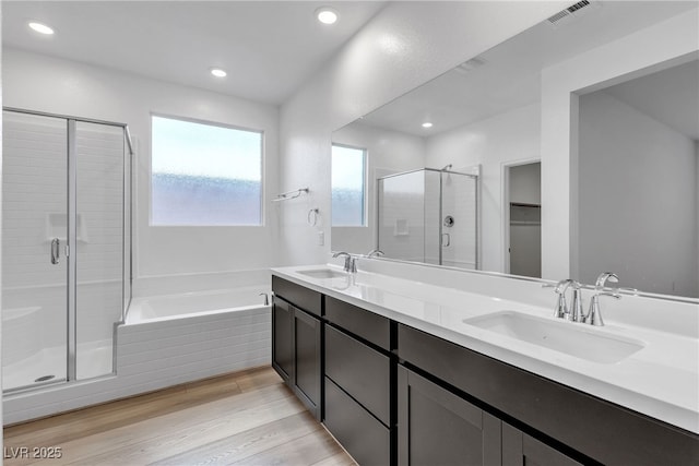 9570 Thistle Creek Ave, Las Vegas, NV 89178 - bathroom with a stall shower, a bath, double vanity, wood finished floors, and recessed lighting