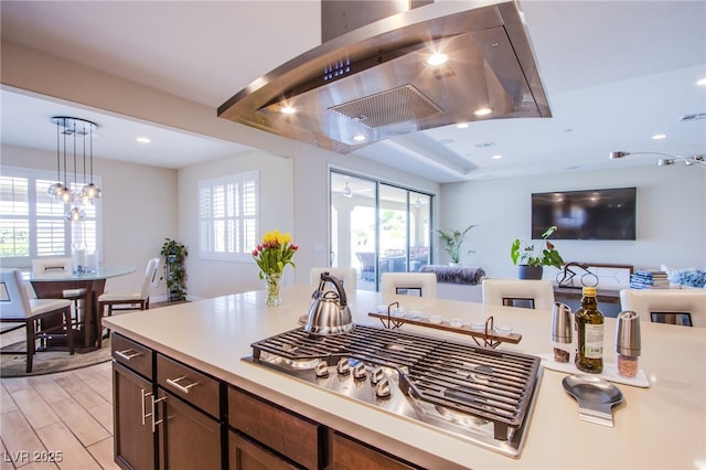 8298 W Agate Ave, Las Vegas, NV 89113 - kitchen featuring ventilation hood, open floor plan, stainless steel gas stovetop, light countertops, and hanging light fixtures