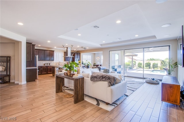 8298 W Agate Ave, Las Vegas, NV 89113 - living room featuring a raised ceiling, light wood finished floors, and recessed lighting