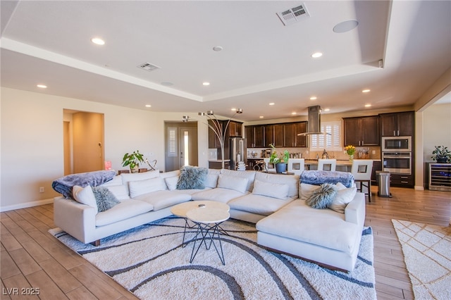 8298 W Agate Ave, Las Vegas, NV 89113 - living area with a raised ceiling, wine cooler, light wood-style floors, and recessed lighting