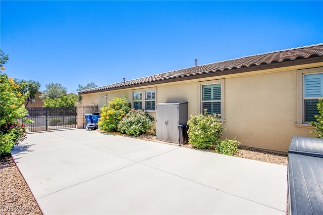 8298 W Agate Ave, Las Vegas, NV 89113 - view of side of home featuring stucco siding, a gate, and a patio