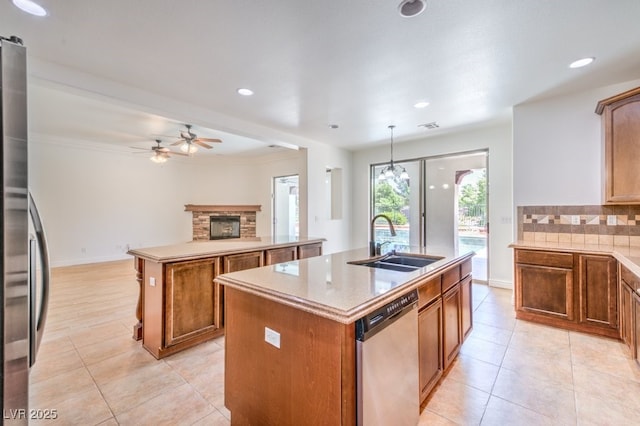 5396 Splendido Ave, Pahrump, NV 89061 - kitchen with stainless steel appliances, a center island with sink, a sink, light tile patterned floors, and backsplash