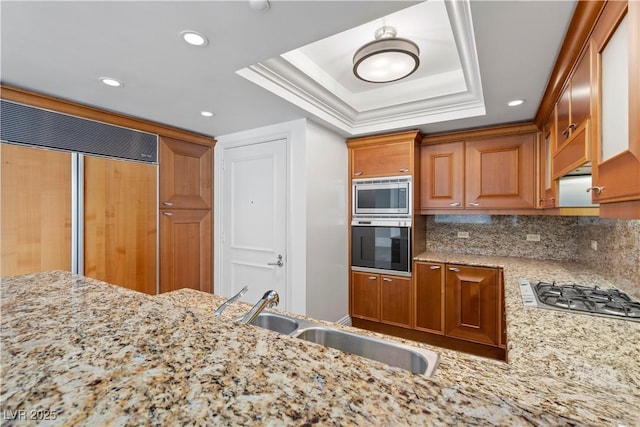 2777 Paradise Rd Unit 1002, Las Vegas, NV 89109 - kitchen with built in appliances, a sink, a raised ceiling, light stone countertops, and recessed lighting