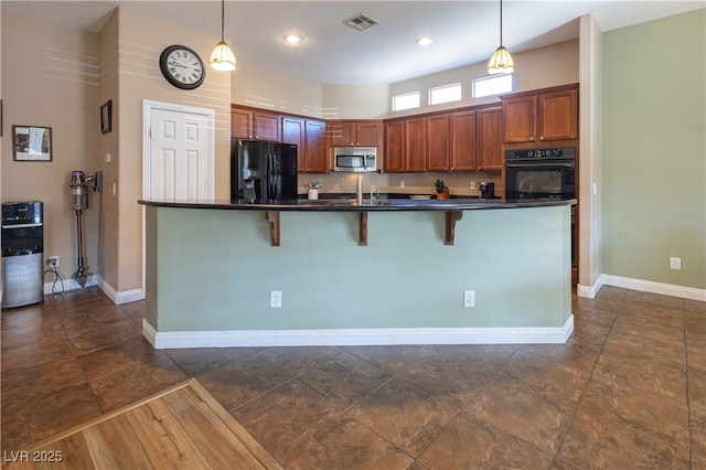 9077 Creed Mountain Pl, Las Vegas, NV 89178 - kitchen with black appliances, dark countertops, a kitchen breakfast bar, pendant lighting, and baseboards