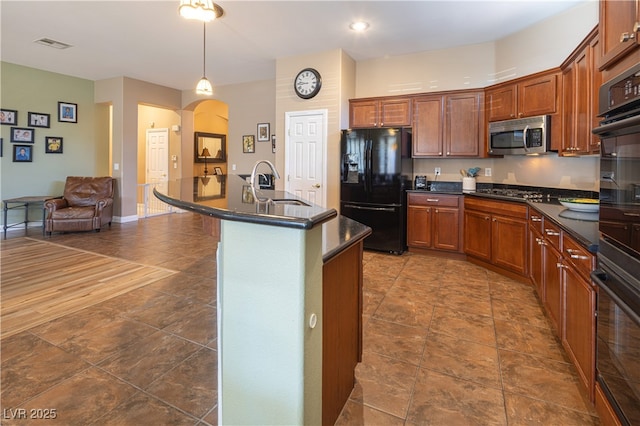 9077 Creed Mountain Pl, Las Vegas, NV 89178 - kitchen featuring appliances with stainless steel finishes, a sink, dark countertops, and arched walkways