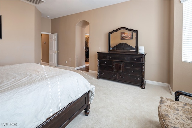 9077 Creed Mountain Pl, Las Vegas, NV 89178 - bedroom with arched walkways, a walk in closet, light carpet, and baseboards