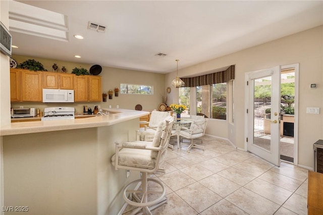 1620 Fieldbrook St, Henderson, NV 89052 - kitchen featuring white appliances, recessed lighting, light tile patterned floors, light countertops, and a kitchen breakfast bar