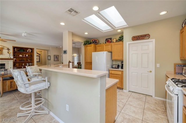 1620 Fieldbrook St, Henderson, NV 89052 - kitchen with white appliances, light tile patterned flooring, a kitchen breakfast bar, light countertops, and recessed lighting