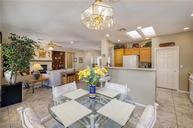 1620 Fieldbrook St, Henderson, NV 89052 - dining area featuring light tile patterned floors, a fireplace, a skylight, recessed lighting, and a chandelier