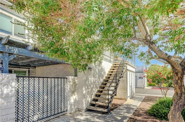 1101 Willow Tree Dr Unit D, Las Vegas, NV 89128 - view of property exterior with stairway, a pergola, and stucco siding