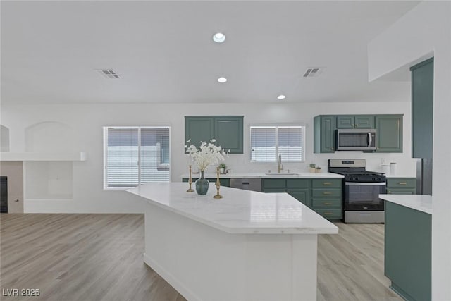 4369 Meadowlark Wing Way N, Las Vegas, NV 89084 - kitchen featuring stainless steel appliances, green cabinets, light wood-type flooring, a kitchen island, and recessed lighting