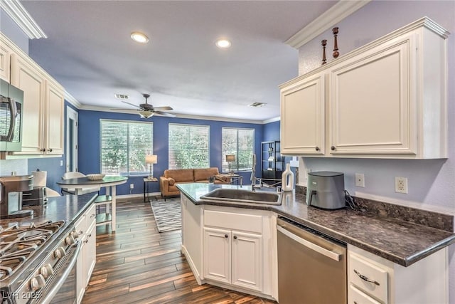 979 Coatbridge St, Las Vegas, NV 89145 - kitchen with appliances with stainless steel finishes, crown molding, ceiling fan, open floor plan, and dark wood-style flooring