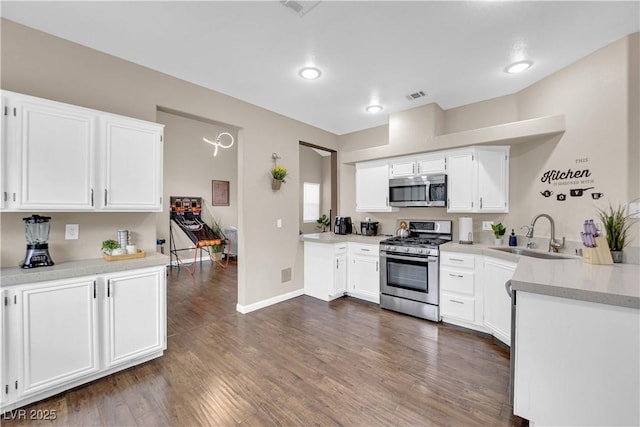 3659 Gerri Bay Ln, Las Vegas, NV 89147 - kitchen with stainless steel appliances, a sink, white cabinetry, light countertops, and dark wood-type flooring