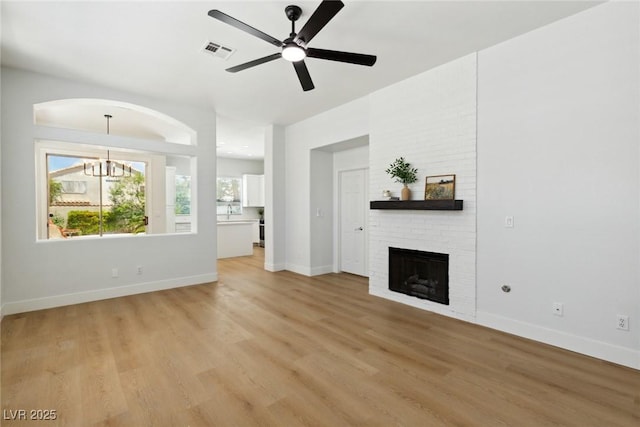 8312 Raphael Ct, Las Vegas, NV 89129 - unfurnished living room with a ceiling fan, light wood-type flooring, a brick fireplace, and baseboards