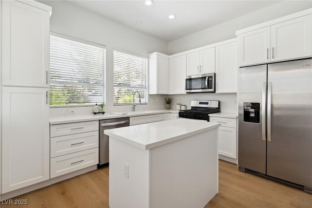 8312 Raphael Ct, Las Vegas, NV 89129 - kitchen with appliances with stainless steel finishes, light wood-style floors, a sink, recessed lighting, and white cabinetry