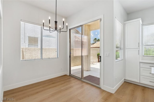 8312 Raphael Ct, Las Vegas, NV 89129 - unfurnished dining area featuring light wood finished floors, a chandelier, and baseboards