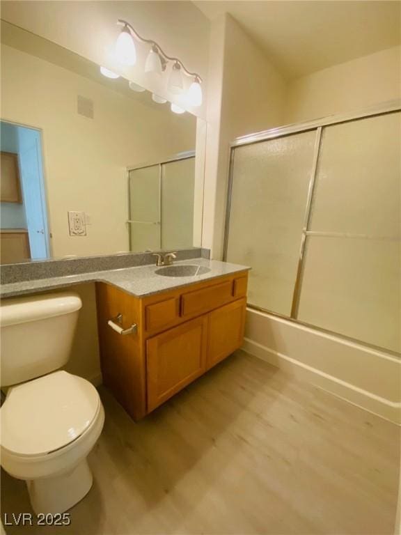 10290 Gilmore Canyon Ct Unit 103, Las Vegas, NV 89129 - bathroom with wood finished floors, toilet, vanity, and enclosed tub / shower combo