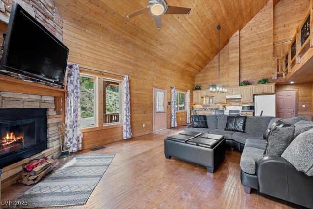 4830 Silver Tip Way, Mount Charleston, NV 89124 - living area with high vaulted ceiling, a ceiling fan, wood ceiling, light wood-style floors, and a stone fireplace