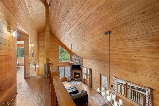 4830 Silver Tip Way, Mount Charleston, NV 89124 - living area with wood walls, wooden ceiling, hardwood / wood-style floors, a stone fireplace, and high vaulted ceiling