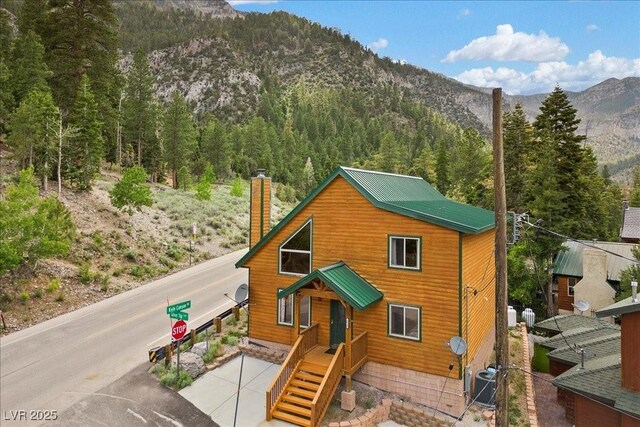 4830 Silver Tip Way, Mount Charleston, NV 89124 - view of front of home with a mountain view, a chimney, cooling unit, and a wooded view