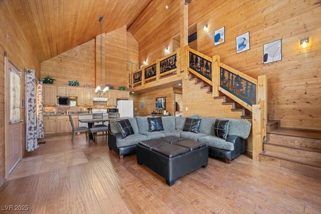 4830 Silver Tip Way, Mount Charleston, NV 89124 - living room featuring high vaulted ceiling, wooden walls, stairs, wooden ceiling, and light wood-style flooring