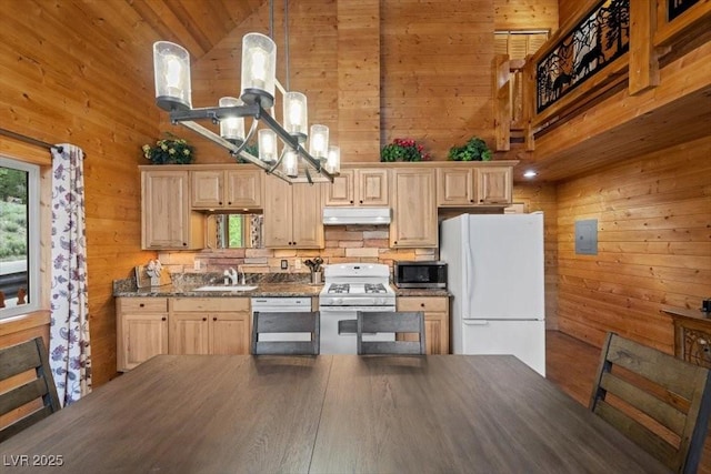 4830 Silver Tip Way, Mount Charleston, NV 89124 - kitchen with white appliances, wood walls, under cabinet range hood, a sink, and a chandelier