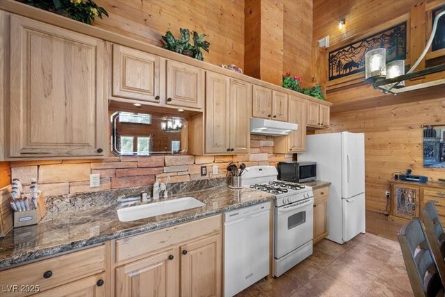 4830 Silver Tip Way, Mount Charleston, NV 89124 - kitchen with white appliances, wooden walls, under cabinet range hood, a sink, and backsplash