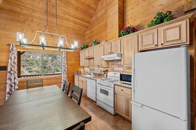 4830 Silver Tip Way, Mount Charleston, NV 89124 - kitchen with white appliances, under cabinet range hood, wood walls, a chandelier, and a sink