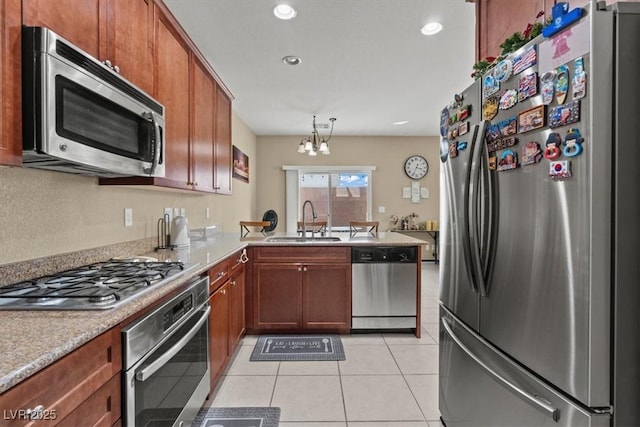5667 Foxglove Field St, Las Vegas, NV 89130 - kitchen with appliances with stainless steel finishes, a sink, a peninsula, a chandelier, and light countertops