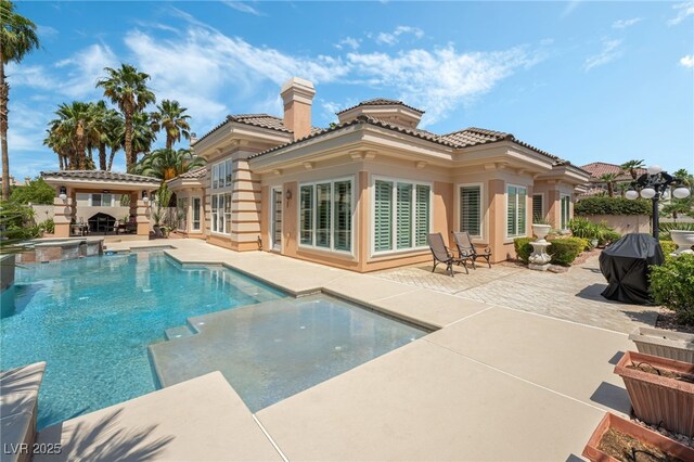 277 Dark Forest Ave, Las Vegas, NV 89123 - rear view of house featuring a patio, a pool with connected hot tub, a chimney, a tile roof, and stucco siding