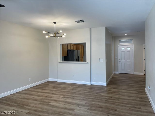 3161 Quail Song Dr Unit 3161, Laughlin, NV 89029 - unfurnished living room with a chandelier, dark wood-style flooring, and baseboards