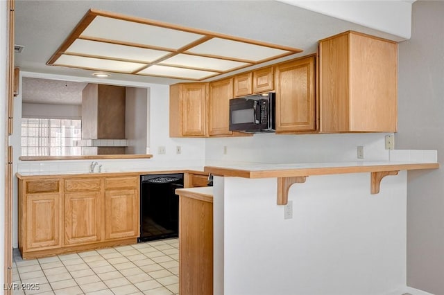 445 Intrepid Ct, Boulder City, NV 89005 - kitchen with black appliances, a kitchen bar, light tile patterned floors, light countertops, and a peninsula