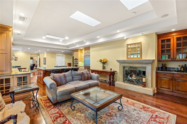 2001 Silver Ave, Las Vegas, NV 89102 - living area featuring a tray ceiling, wood-type flooring, a warm lit fireplace, a skylight, and ornamental molding