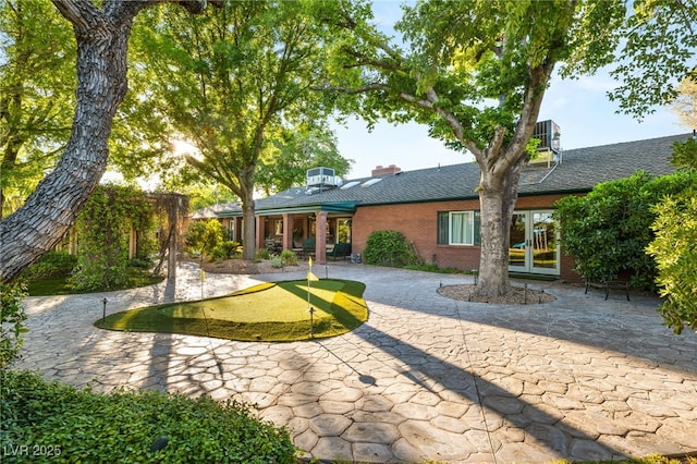 2001 Silver Ave, Las Vegas, NV 89102 - back of house with a putting area, a patio, brick siding, french doors, and a chimney