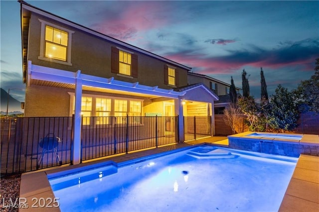 2832 Aragon Terrace Way, Henderson, NV 89044 - back of house at dusk featuring stucco siding and a pool with connected hot tub