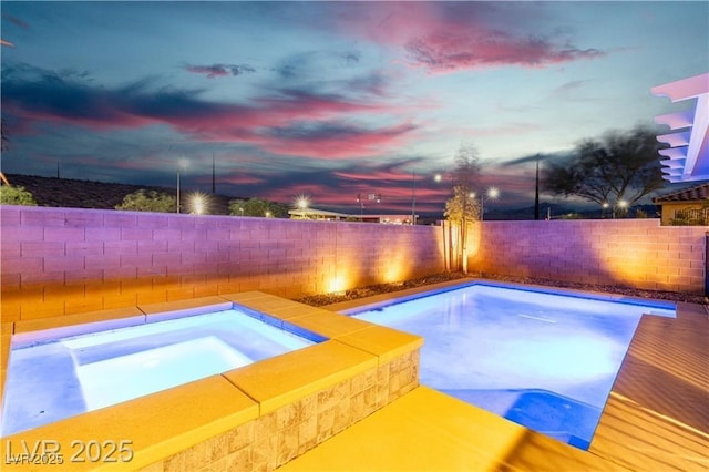 2832 Aragon Terrace Way, Henderson, NV 89044 - pool at dusk featuring an in-ground hot tub and a fenced backyard