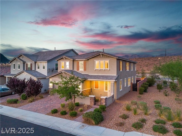 2832 Aragon Terrace Way, Henderson, NV 89044 - view of front of house with stucco siding, decorative driveway, a fenced front yard, a gate, and a mountain view