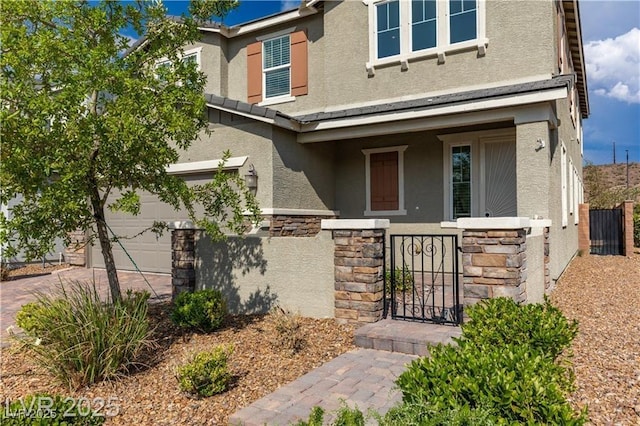 2832 Aragon Terrace Way, Henderson, NV 89044 - view of front of property with stucco siding, stone siding, an attached garage, and a gate