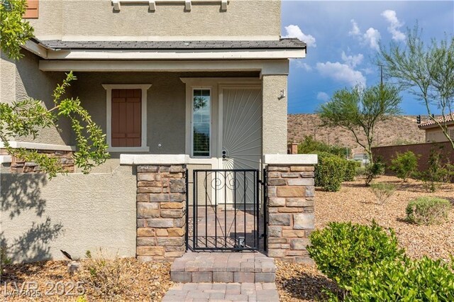 2832 Aragon Terrace Way, Henderson, NV 89044 - doorway to property featuring stucco siding, a gate, and stone siding