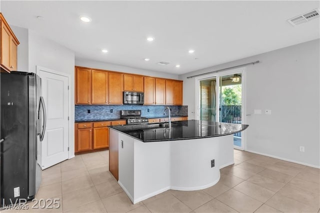 2832 Aragon Terrace Way, Henderson, NV 89044 - kitchen with stainless steel appliances, a sink, brown cabinetry, backsplash, and light tile patterned floors