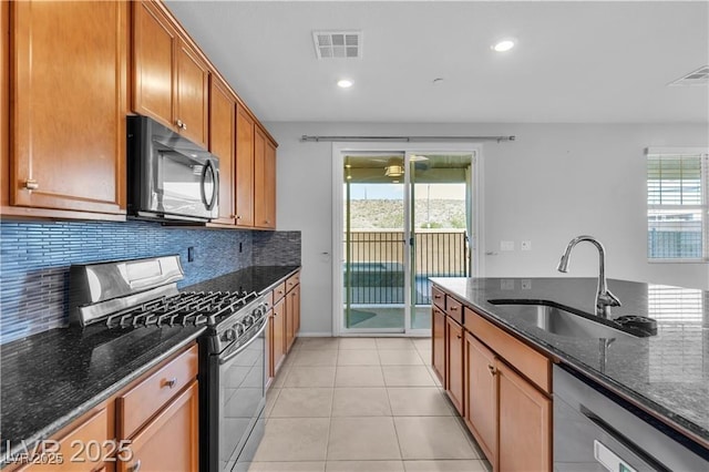 2832 Aragon Terrace Way, Henderson, NV 89044 - kitchen with black microwave, range with gas cooktop, a sink, dishwasher, and dark stone countertops