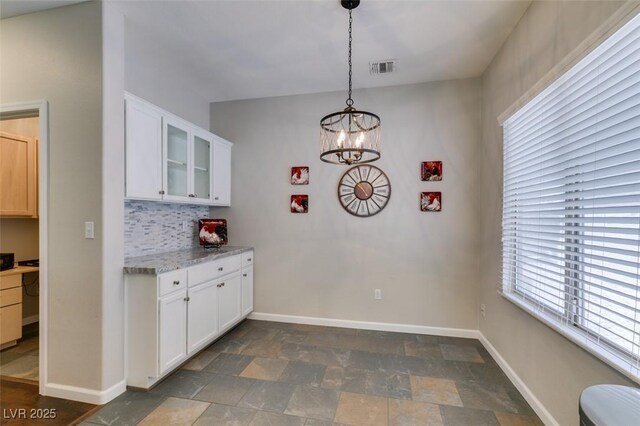 2111 Tiger Links Dr, Henderson, NV 89012 - kitchen featuring stone finish floors, glass insert cabinets, white cabinetry, and baseboards