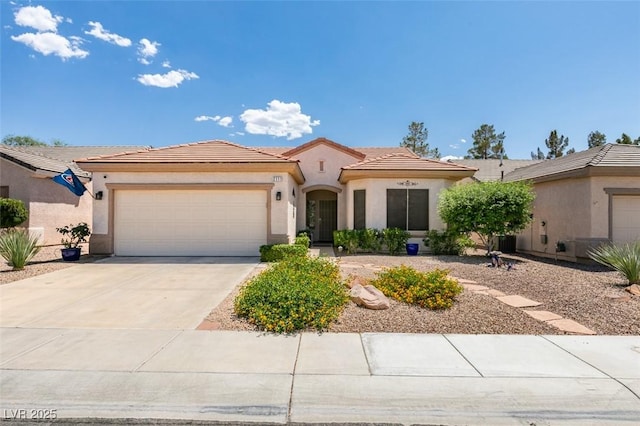 2111 Tiger Links Dr, Henderson, NV 89012 - view of front of house featuring a garage, a tile roof, stucco siding, and concrete driveway