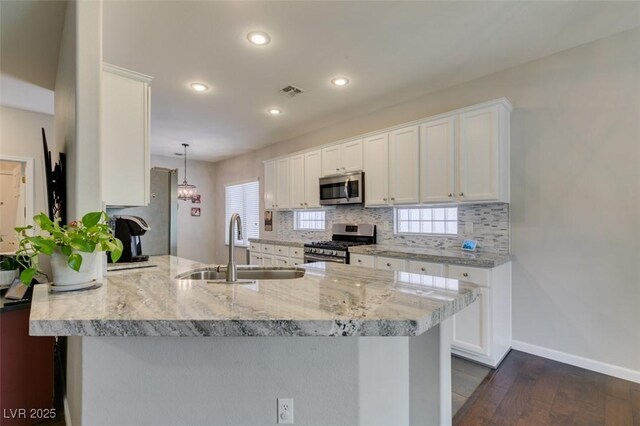 2111 Tiger Links Dr, Henderson, NV 89012 - kitchen featuring appliances with stainless steel finishes, a sink, a peninsula, white cabinetry, and recessed lighting