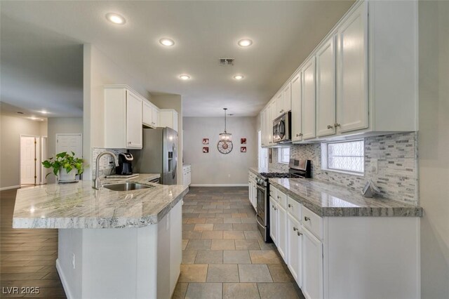 2111 Tiger Links Dr, Henderson, NV 89012 - kitchen featuring appliances with stainless steel finishes, a sink, baseboards, recessed lighting, and a peninsula