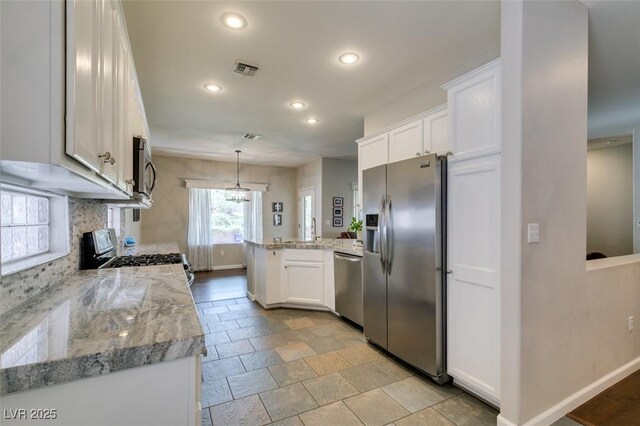 2111 Tiger Links Dr, Henderson, NV 89012 - kitchen with appliances with stainless steel finishes, a peninsula, baseboards, recessed lighting, and white cabinetry